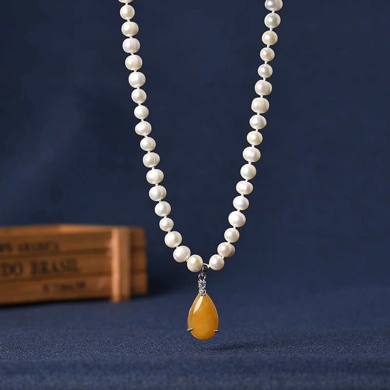 Lašo formos, oranžinės-geltonos spalvos 17*26*8 mm, pakabukas suporuotas su maža balta 8-9 mm Natūralių perlų vėrinį, susiję sidabro grandinės